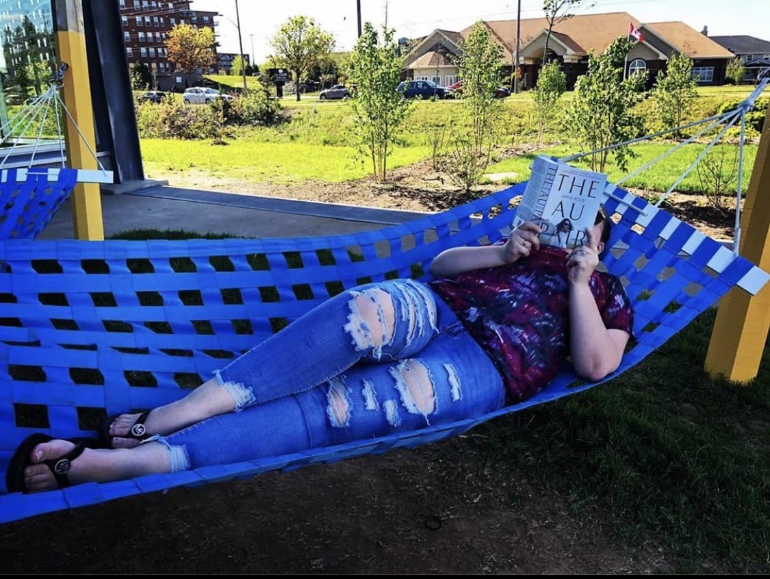 Christina Halliday laying on a hammock reading the Au Pair by Emma Rous